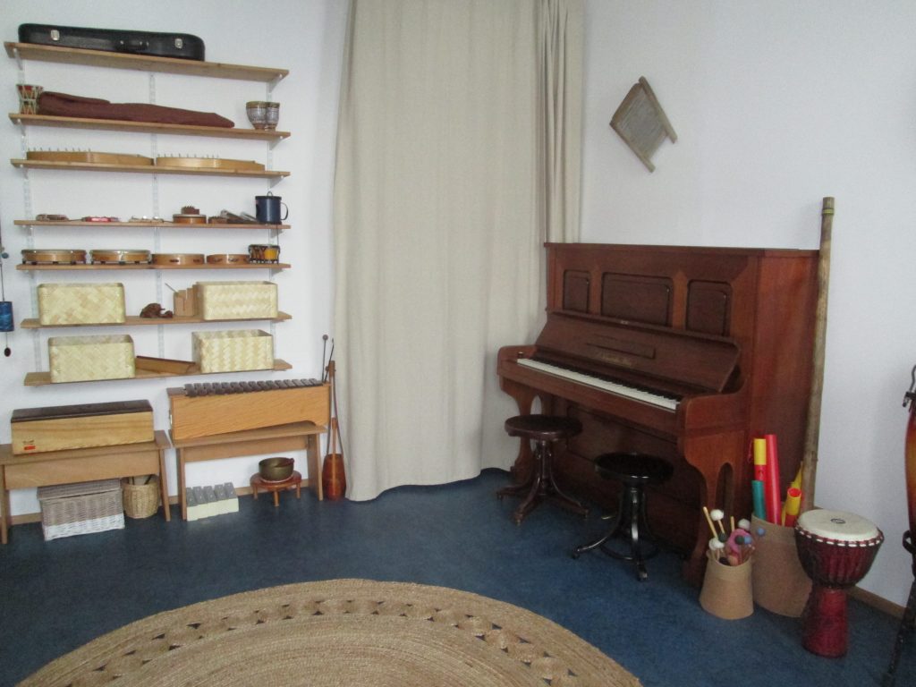 Musiktherapiepraxis: Raum mit Klavier und div. Kleininstrumenten
